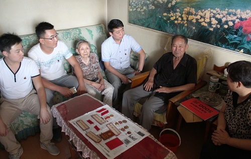 8月21日，曹来昌老人（右二）为团员们讲述自己的经历。